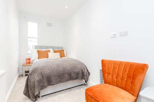 伦敦Bright & Modern 2-Bed Notting Hill Apartment的一间卧室配有一张床和一把椅子