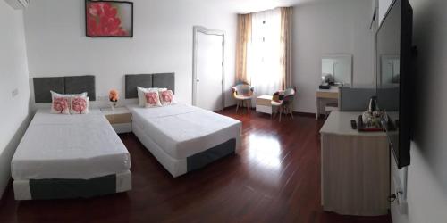 斯里巴加湾市Coconut Bay Lodge的酒店客房配有两张床和一张书桌