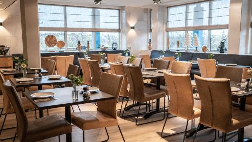 比伦布伦海滨酒店的用餐室设有桌椅和窗户。