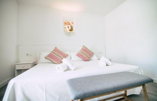 雅弗郎其Hostal La Llagosta的一间卧室配有一张白色床和蓝色凳子