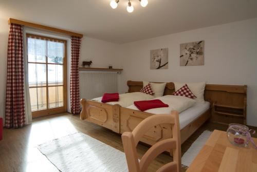 韦尔塔赫Weißenbach´s Ferienhof的一间卧室配有一张带红色枕头的大型木制床。
