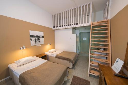 努尔梅斯Hyvärilä Youth- and Holiday Centre的小房间设有两张床和楼梯