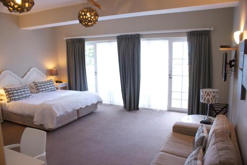 赫曼努斯鲸鱼岩豪华旅舍的一间卧室配有一张床和一张沙发