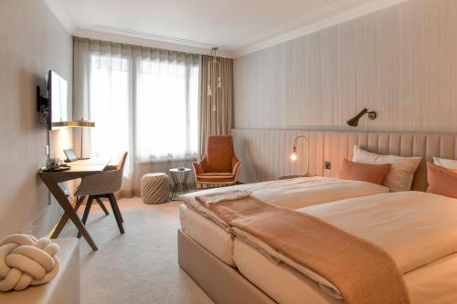 达沃斯孔格里斯酒店的一间卧室配有一张大床、一张桌子和一把椅子