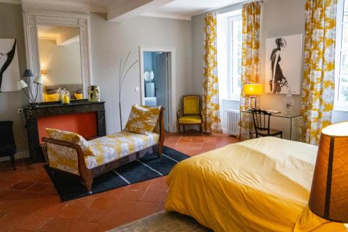 LempautChâteau de la Bousquetarie的一间卧室配有一张床、一把椅子和一个壁炉