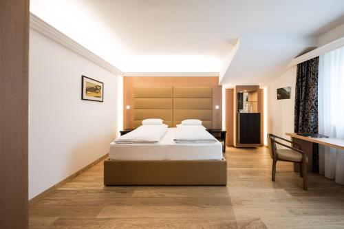 卡尔达罗Hotel Haus am Hang的酒店客房配有两张床和一张书桌
