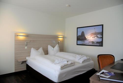罗斯托克富米汀布伦纳公寓酒店的酒店客房设有一张白色的床,墙上挂着一张照片