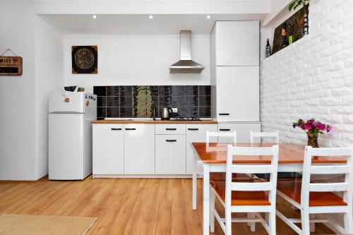 第比利斯31 Toidze Apartment的厨房配有白色橱柜和木桌