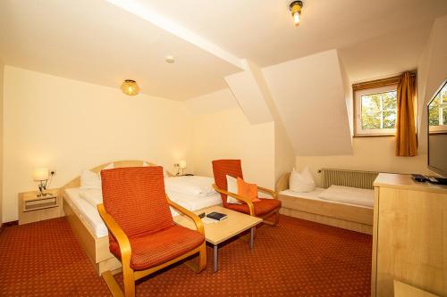 阿尔戈伊地区洛伊特基希Hotel Post Leutkirch的一间卧室配有一张床、两把椅子和一张桌子