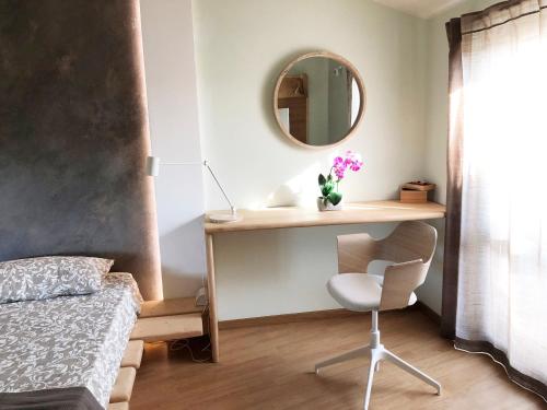 安圭拉萨巴齐亚REnt Room Wood的一间卧室配有书桌、镜子和椅子
