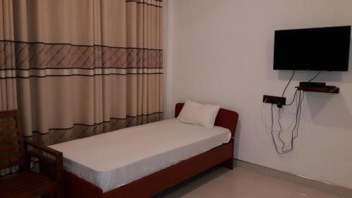 波隆纳鲁沃里森拉克度假酒店的小房间设有一张小床和一台平面电视