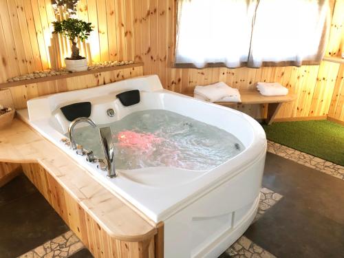 安圭拉萨巴齐亚REnt Room Wood的木制浴室内设有大型白色浴缸。