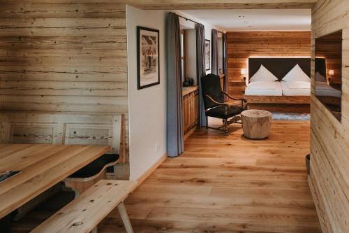 格门德蒂格斯Tegernseer Hof的客房设有木墙、一张床和一张书桌