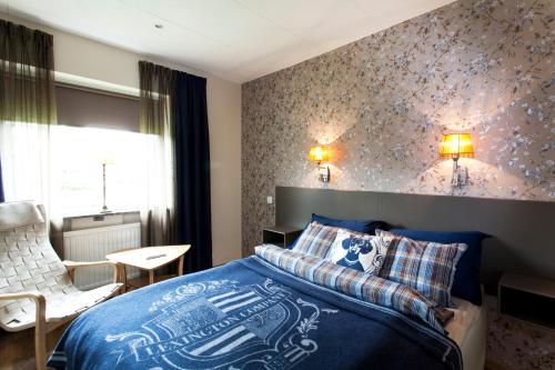 BredarydWärdshuset Bredaryd的一间卧室配有蓝色的床和椅子