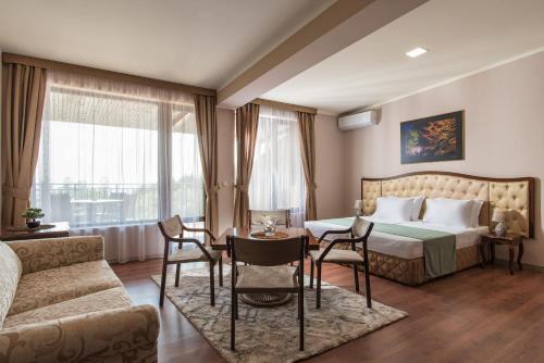 KladnitsaHotel Villa Magus的酒店客房带一张床、一张桌子和椅子