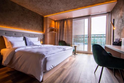 丁克尔斯比尔Meiser Design Hotel的一间卧室设有一张大床和一个大窗户