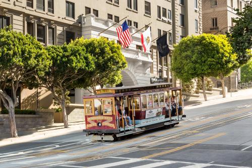 旧金山旧金山斯坦福庭院酒店的一辆有美国国旗的电车沿着城市街道行驶