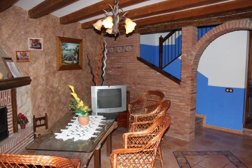 Villafeliche劳拉卡萨乡村民宿的客厅配有桌椅和电视。