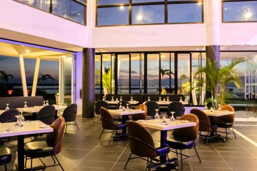 拉古洼Doulos Phos The Ship Hotel的餐厅设有桌椅和窗户。