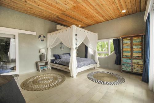海神庙Coco Verde Bali Resort的一间卧室配有一张带天蓬的床