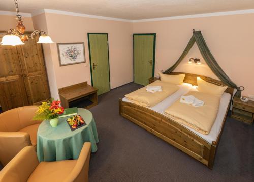 Tannenberg索瓦德酒店的一间卧室配有一张床、一张沙发和一张桌子