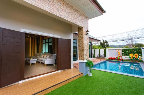 梭桃邑Uzeason Poolvilla Sattahip的一个带游泳池和房子的后院