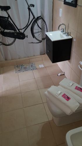 乌拉圭河畔康塞普西翁Antigua Fonda Duplex Studio的浴室设有挂在厕所和水槽上方的自行车