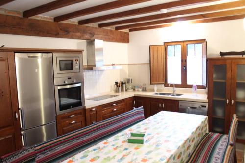 Villayuso de CiezaCasa Rural Reserva Saja-Besaya的厨房配有桌子和不锈钢冰箱。