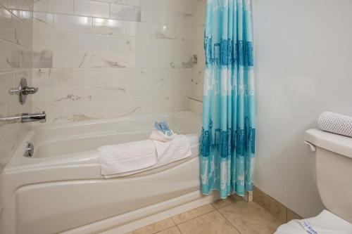 镭温泉Gables Motel的带浴缸和卫生间的浴室。