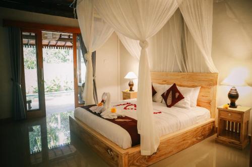乌布Private Villa with nature atmosphere by Pondok Dino的一间卧室配有一张带天蓬的床