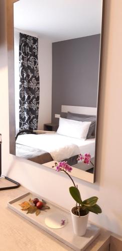 辛德尔芬根City Vibes Hotel的镜子反射着卧室,卧室配有床