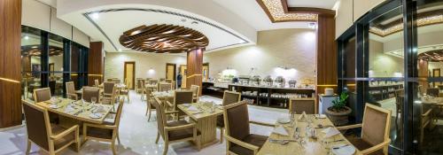 马斯喀特Muscat Gate Hotel的一间带桌椅的餐厅和一间酒吧