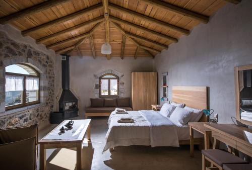 KapetanianáThalori Traditional Ecotourism Village的一间卧室配有一张床、一张桌子和一张沙发