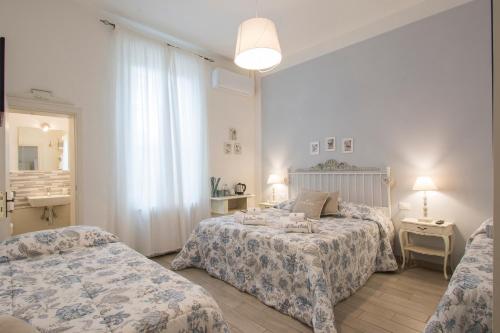 卡尔米尼亚诺B&B La Casa di Otello的一间卧室配有两张床、一张桌子和一面镜子
