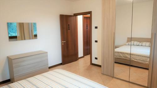 PonsoAppartamento Ciesazza的客房设有带一张床和镜子的卧室