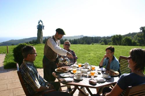 贝梅奥Eco Hotel Rural Lurdeia - Adults Only的一群人坐在野餐桌旁