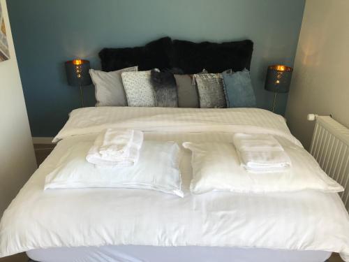 弗吕济Dalabyggd Cottages - Romantic stay by the Secret Lagoon的一张白色大床,上面有两张折叠毛巾