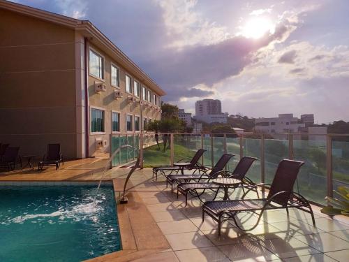 欧鲁布兰科塞拉皇宫酒店 的一组椅子坐在游泳池旁