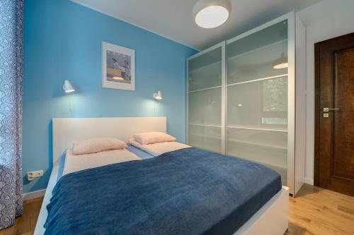 索波特Aquarius & FREE PARKING的一间卧室拥有蓝色的墙壁,配有一张带两个枕头的床