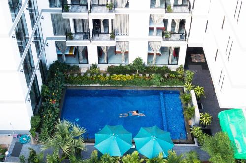 暹粒CENTRAL BLANCHE Residence的享有带遮阳伞的大楼游泳池的顶部景致