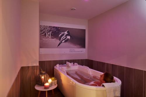 贝诺代Hotel Kastel & Spa avec piscine d'eau de mer chauffée的儿童在客房内的浴缸里