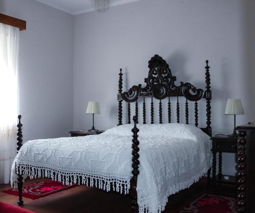 莫加多鲁Casa das Indrineiras的卧室配有带白色棉被的床