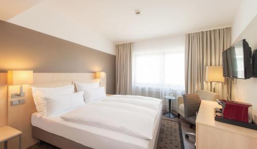 科隆莱斯基辰酒店的酒店客房设有一张白色大床和一台电视。