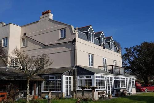 利斯卡德Great Trethew Manor Hotel & Self Catering Lodges的一座白色的大建筑,有很多窗户