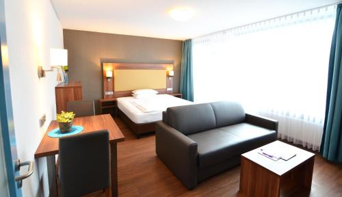 海德堡新海德堡公寓旅馆的酒店客房配有床、沙发和桌子。