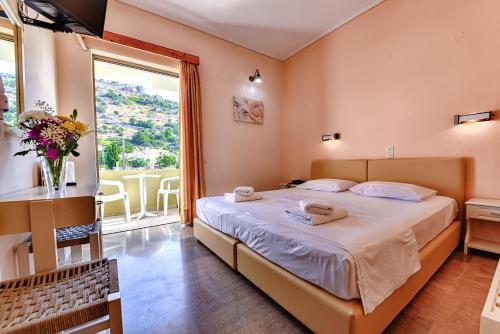 卡拉瓦杜斯伊奥尼斯酒店的一间卧室设有一张大床和一个大窗户