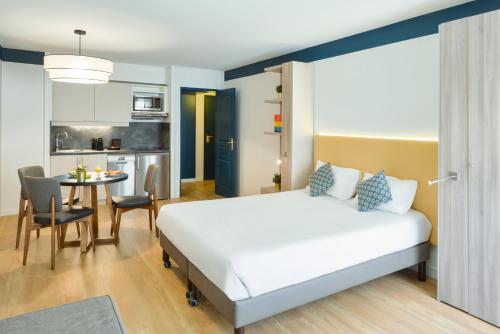 博索莱伊摩纳哥约瑟芬宫阿德吉奥公寓式酒店的酒店客房配有一张床铺和一张桌子。