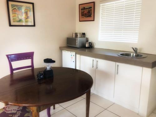 斯泰伦博斯BlackHorse Accommodation的厨房配有桌子和水槽
