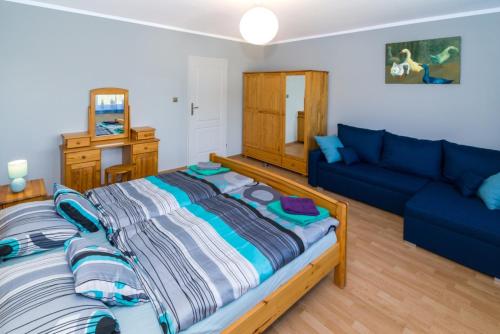 库多瓦-兹德鲁伊Pokoje gościnne Norbu的一间卧室配有一张大床和一张蓝色的沙发