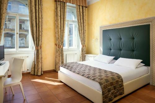 布拉格凯撒布拉格酒店的卧室配有一张床、一张书桌和窗户。